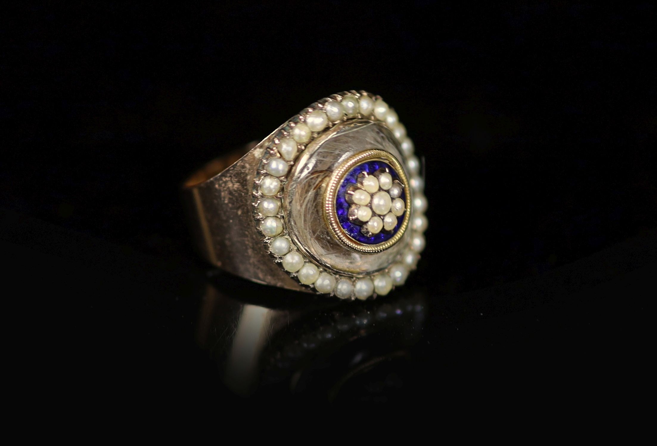 A Victorian gold, enamel seed pearl and rock crystal set oval mourning ring